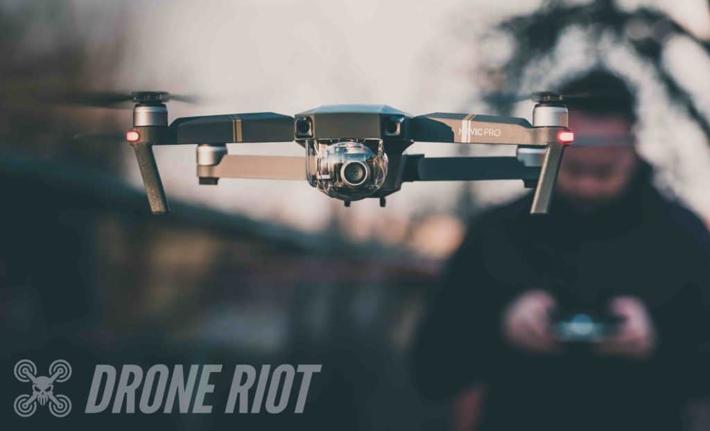 Man with DJI remote flying Mavic Hovering DJI Mavic